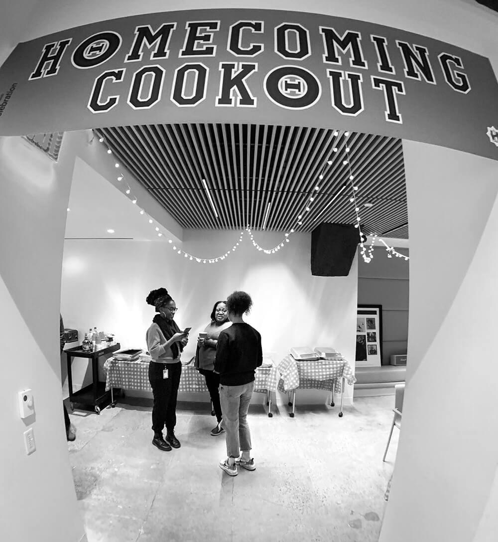 People standing under a homecoming cookout sign