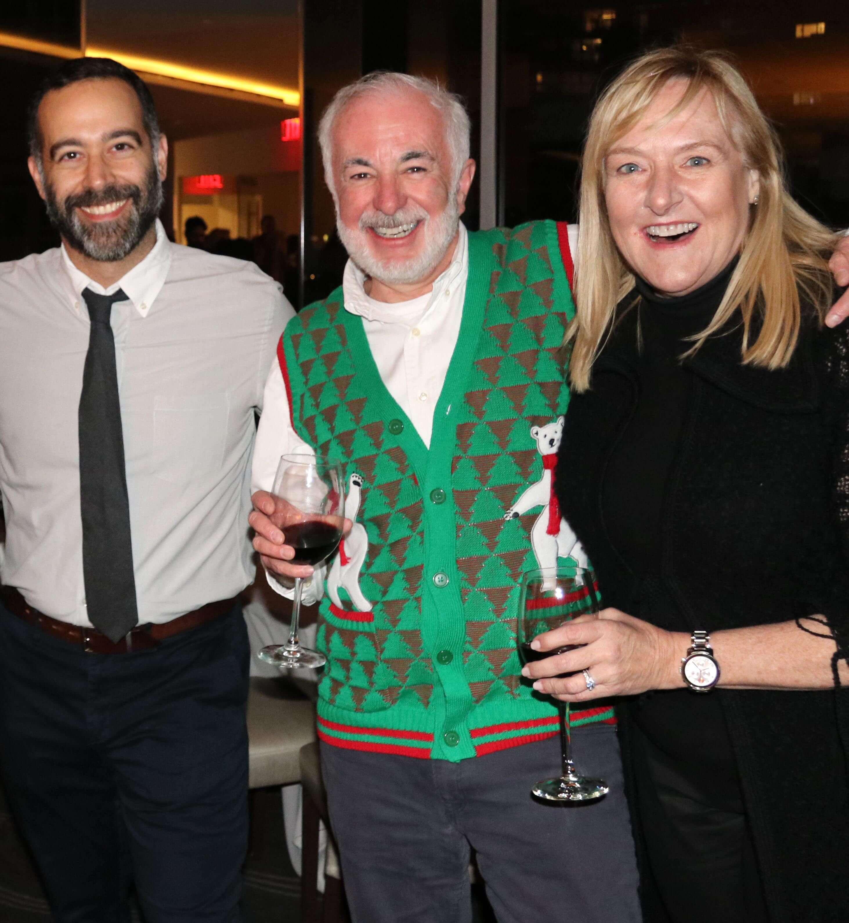 Three people smiling an at office event